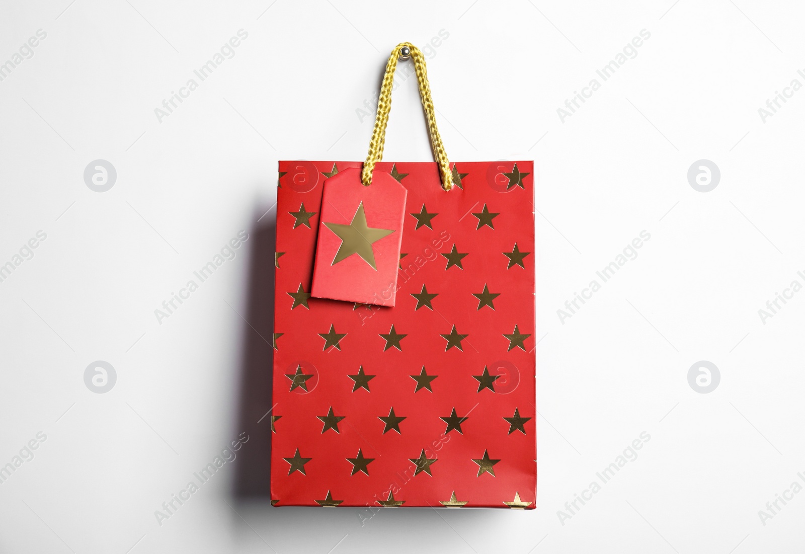 Photo of Red shopping paper bag with star pattern isolated on white