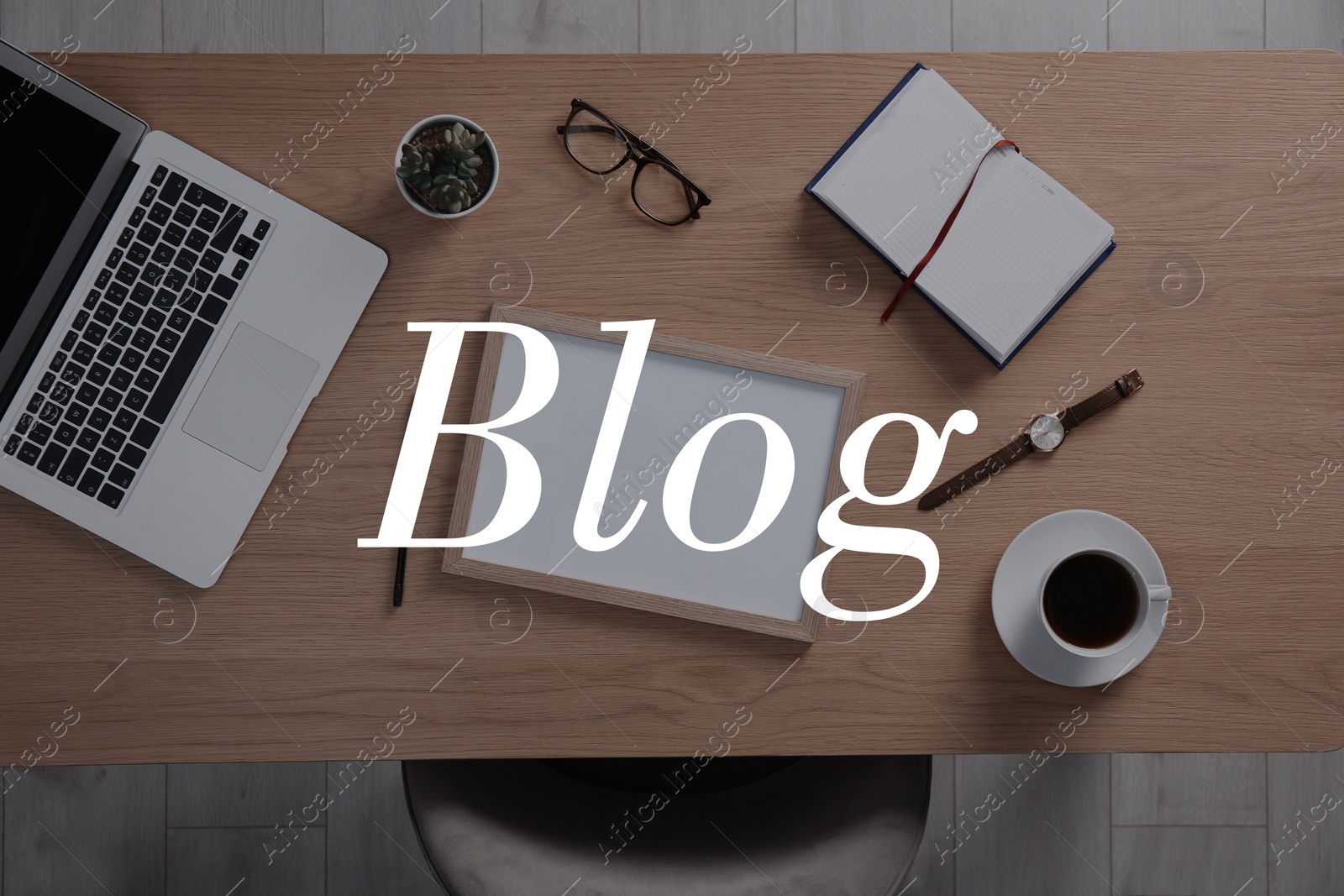 Image of Blogger's workplace with laptop and stationery on wooden table, flat lay