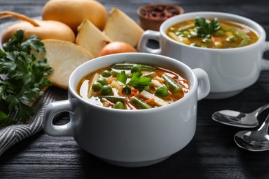 Photo of Bowls of tasty turnip soup on dark wooden table