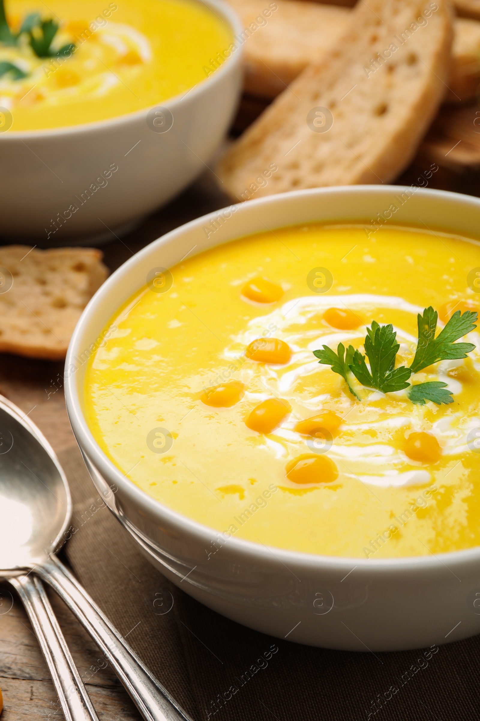 Photo of Delicious creamy corn soup served on table, closeup