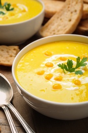 Photo of Delicious creamy corn soup served on table, closeup