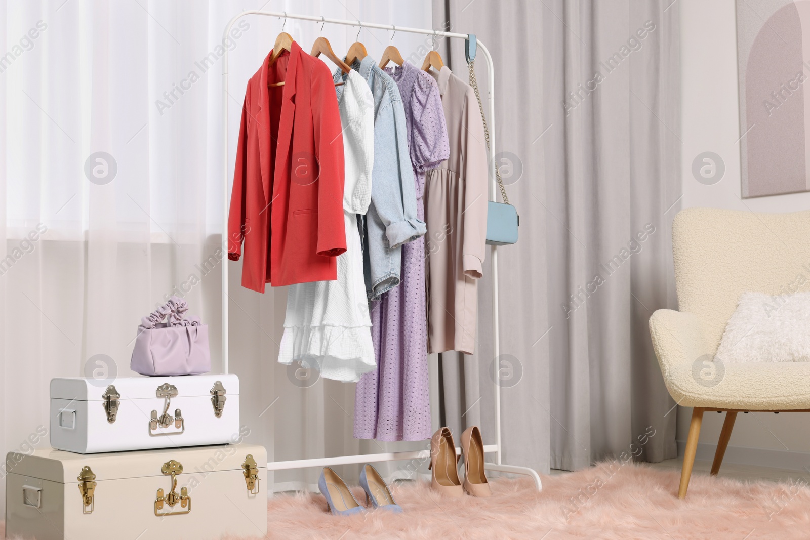 Photo of Clothing rack with stylish women's clothes on hangers in boutique