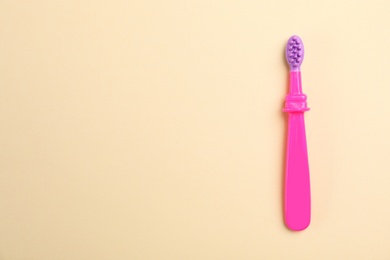 Manual toothbrush for child on color background, top view with space for text