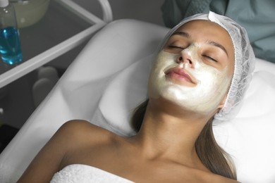 Beautiful woman with mask on her face in spa salon