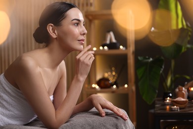 Photo of Spa therapy. Beautiful young woman lying on massage table in salon, space for text