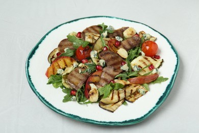 Photo of Delicious salad with beef tongue, grilled vegetables, peach and blue cheese on white table