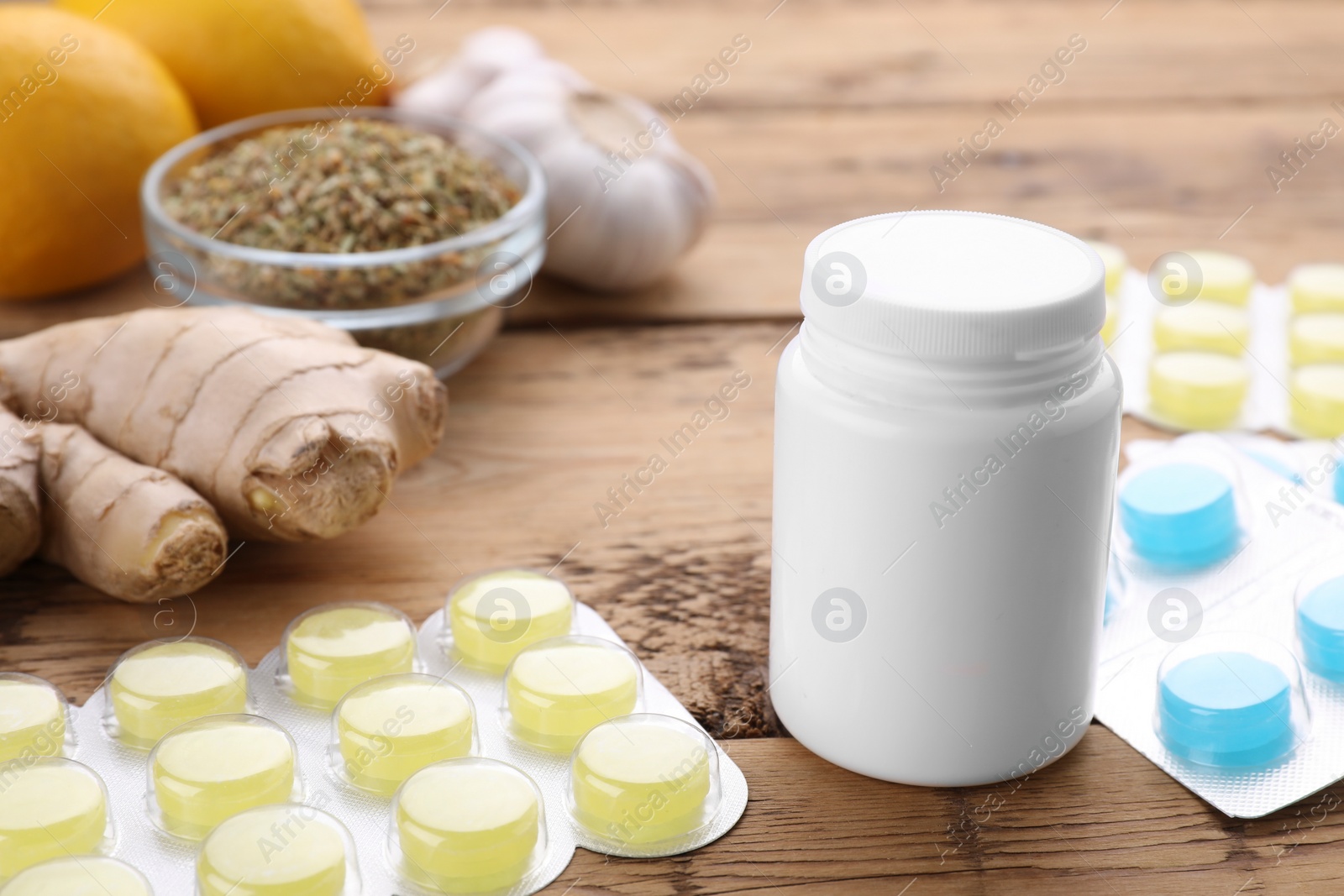 Photo of Cold remedies and pills on wooden table, closeup. Cough treatment