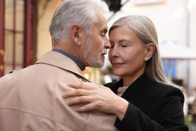 Photo of Affectionate senior couple dancing together on city street