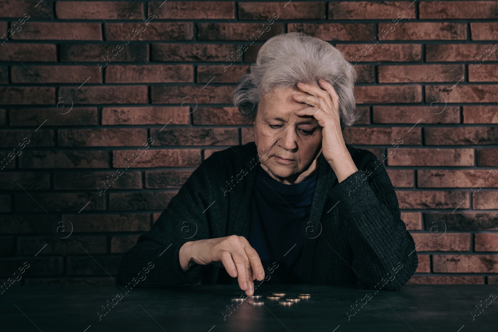 Photo of Mature poor woman counting coins at table. Space for text