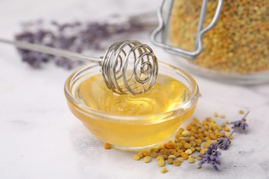 Fresh honey in bowl, dipper, bee pollen granules and lavender on light table, closeup