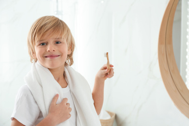 Photo of Cute little boy brushing teeth in bathroom