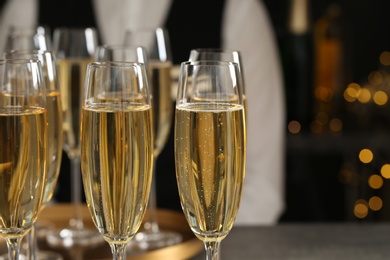 Glasses of champagne and waiter in restaurant, closeup. Space for text