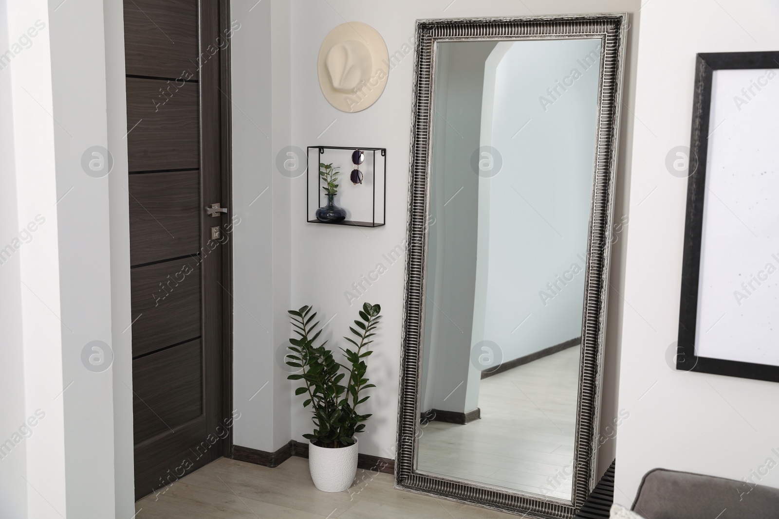 Photo of Modern hallway interior with large mirror and houseplant near door