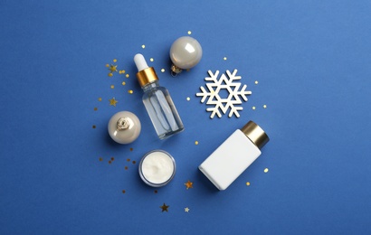 Flat lay composition with cosmetic products on blue background. Winter care