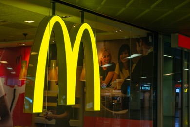 Photo of WARSAW, POLAND - AUGUST 05, 2022: Signboard with McDonald's logo on glass wall in restaurant