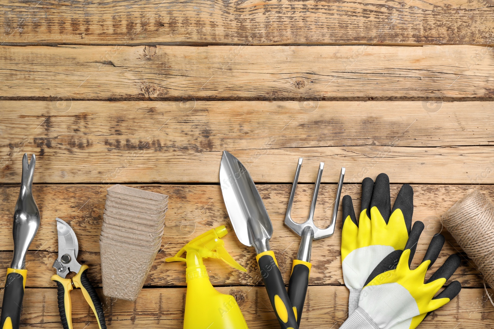 Photo of Flat lay composition with gardening tools on wooden background, space for text