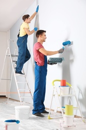 Male decorators refurbishing empty room