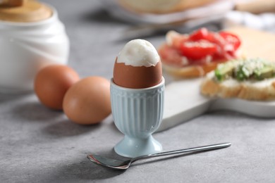 Photo of Tasty boiled chicken egg served for breakfast on light grey table