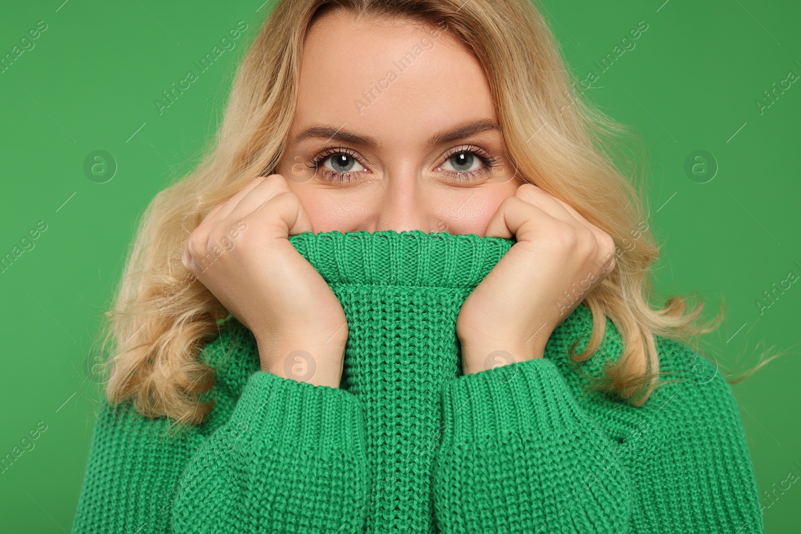 Photo of Beautiful woman in stylish warm sweater on green background