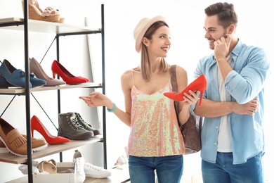 Photo of Young couple choosing shoes in store