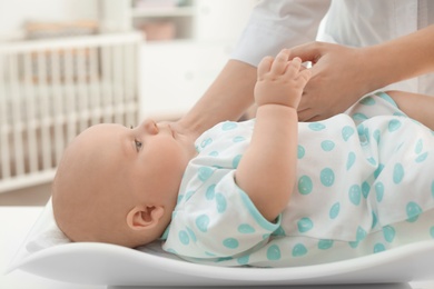 Doctor weighting baby on scales in light room