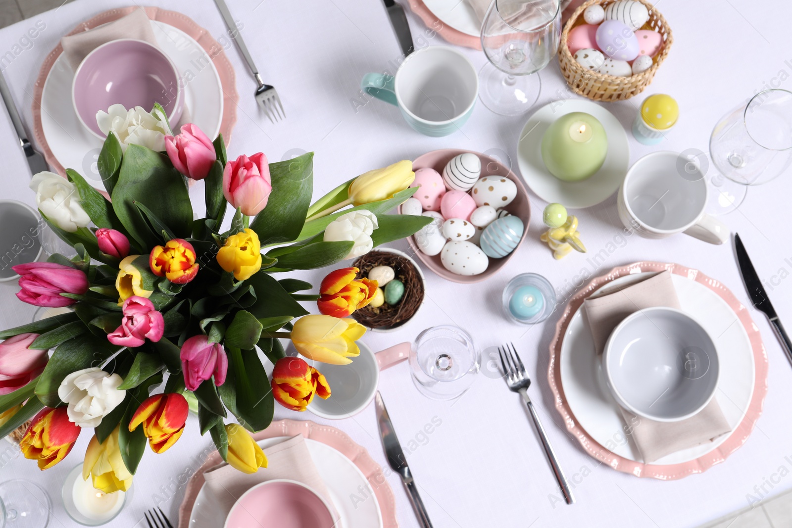 Photo of Festive table setting with beautiful flowers, flat lay. Easter celebration