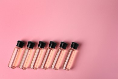 Photo of Bottles of cosmetic products on pink background, flat lay. Space for text