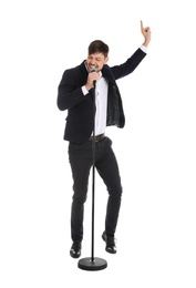 Photo of Handsome man in suit singing with microphone on white background