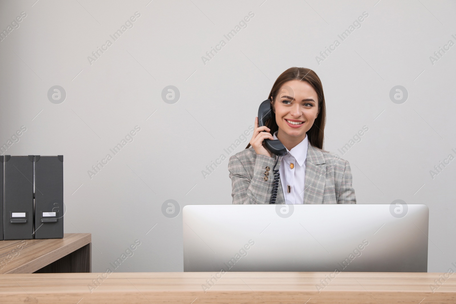 Photo of Female receptionist talking on phone at workplace