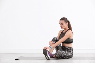 Photo of Female athlete suffering from leg pain during training indoors