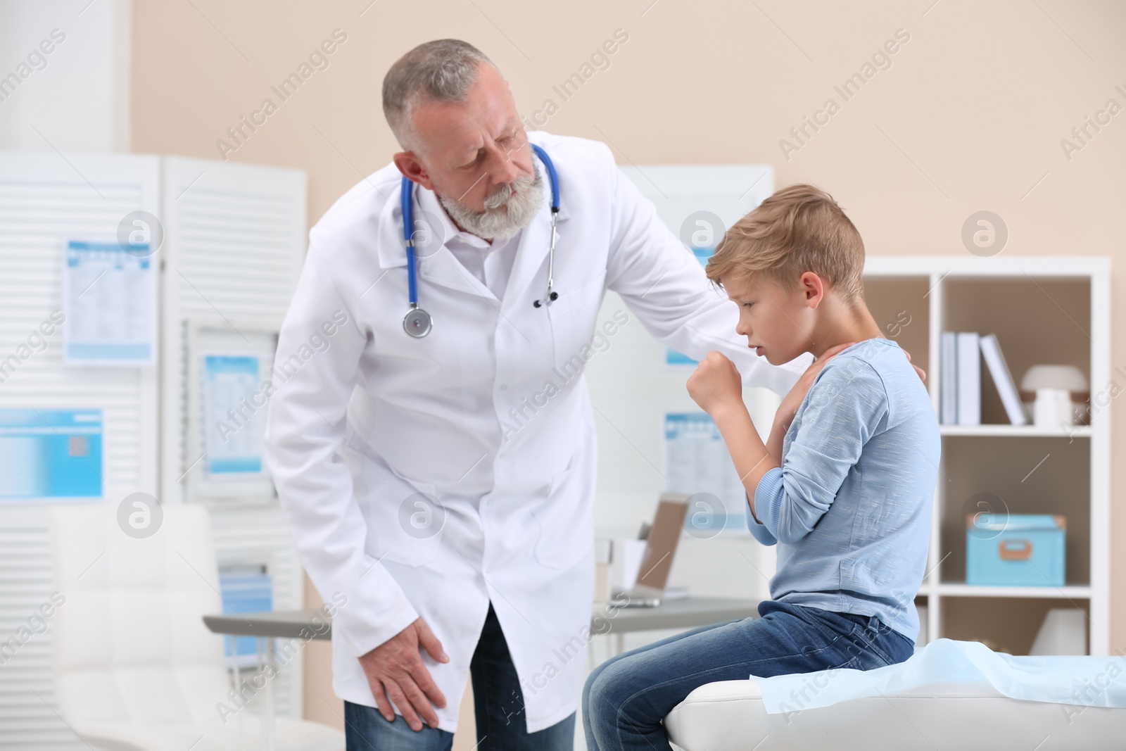 Photo of Coughing little boy visiting doctor at clinic
