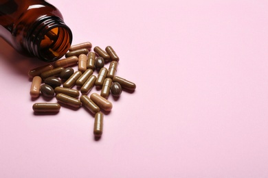 Photo of Bottle with vitamin capsules on color background, space for text