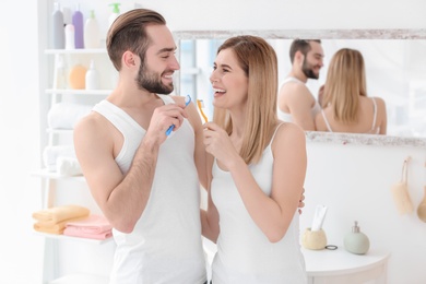 Young couple brushing teeth together in bathroom