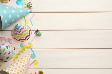 Photo of Flat lay composition with party hats and other festive items on white wooden background. Space for text