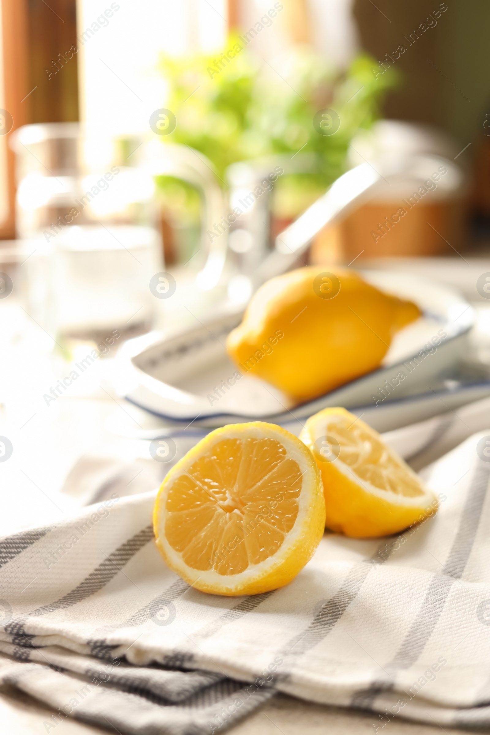 Photo of Halves of fresh ripe lemon on countertop in kitchen, space for text