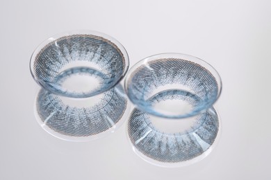 Photo of Two blue contact lenses on mirror surface