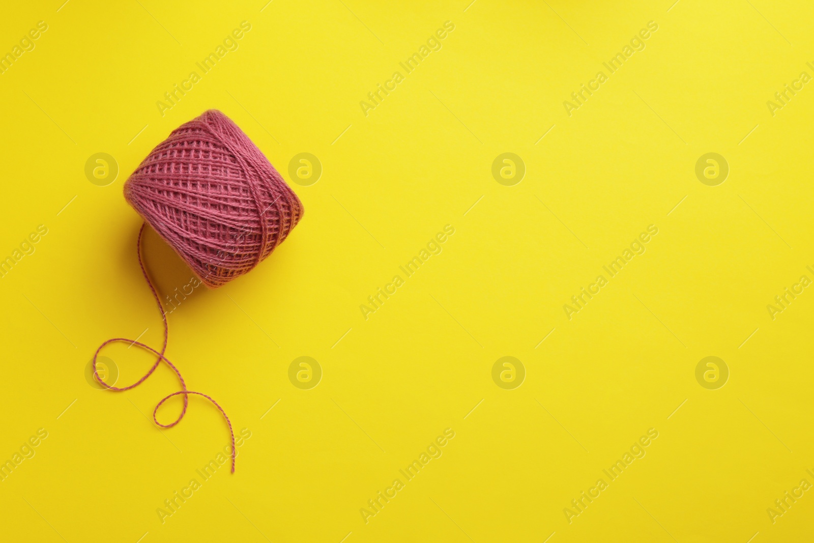 Photo of Clew of knitting threads on color background, top view with space for text. Sewing stuff