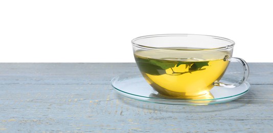 Refreshing green tea in cup on grey wooden table against white background