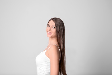 Photo of Portrait of young woman with long beautiful hair on light background