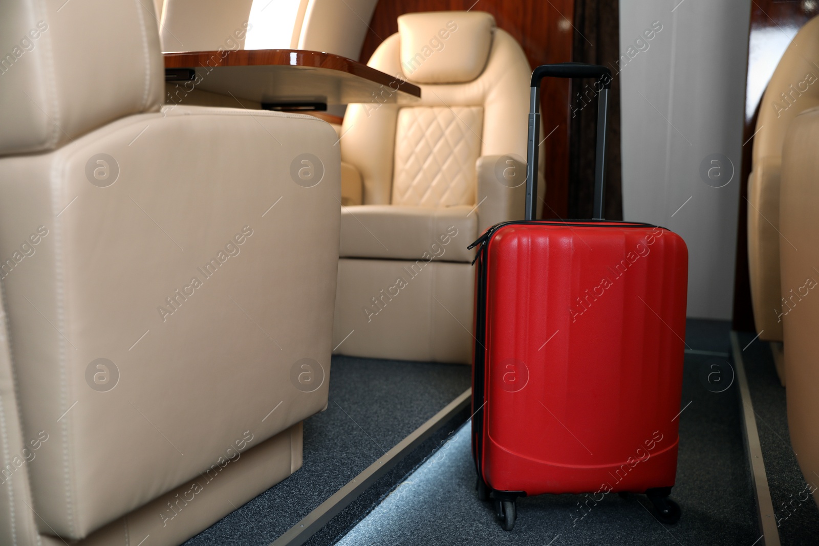 Image of Airplane cabin with red suitcase. Air travel