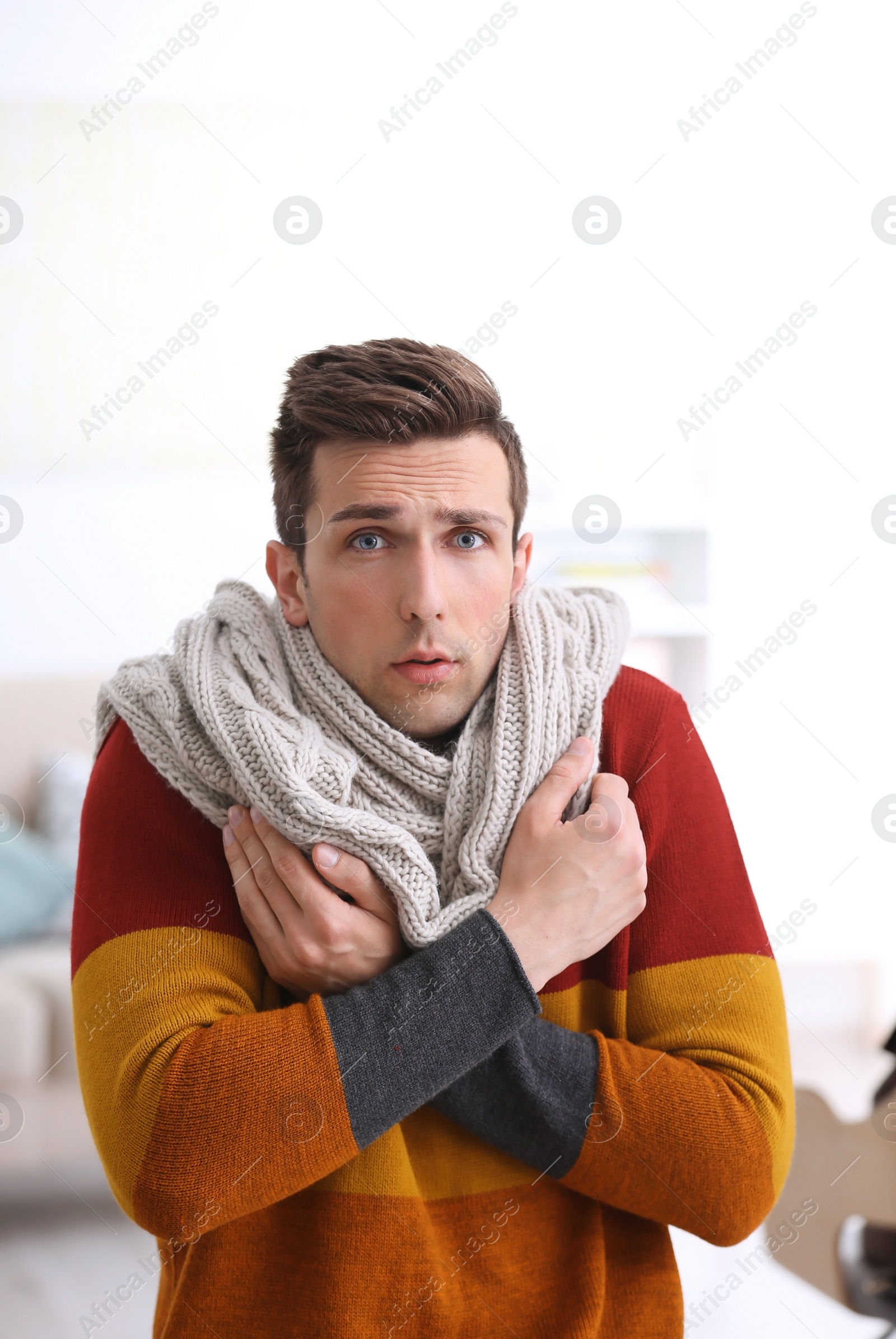 Photo of Sad young man suffering from cold on blurred background