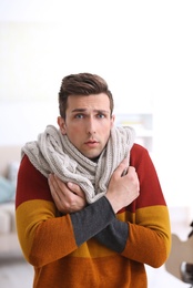Photo of Sad young man suffering from cold on blurred background