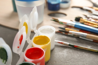 Different paints and brushes on grey table, closeup