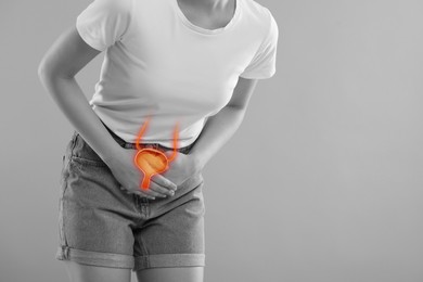 Image of Woman suffering from cystitis on light grey background, closeup. Illustration of urinary system