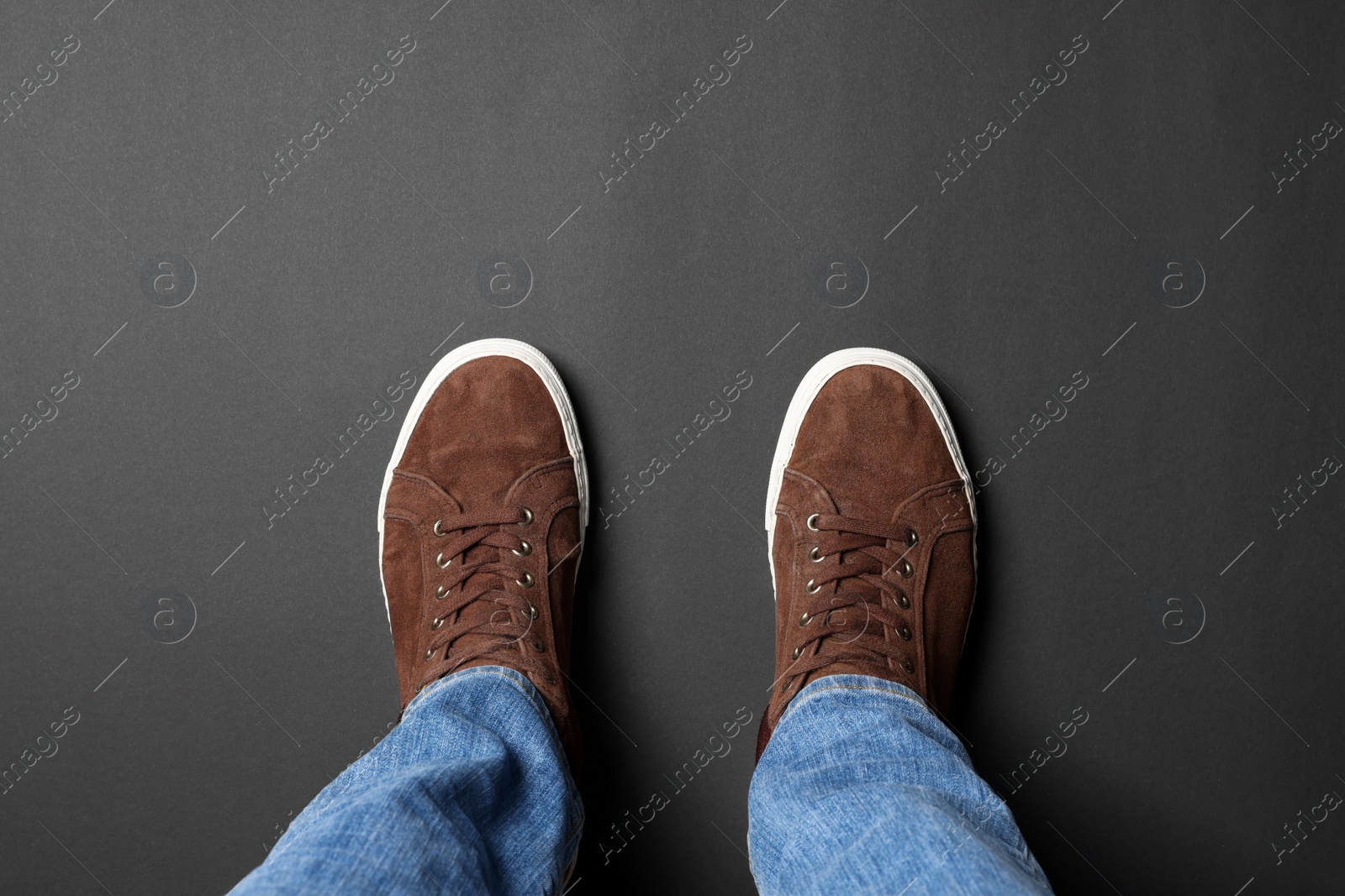 Photo of Man in brown shoes standing on grey background, top view