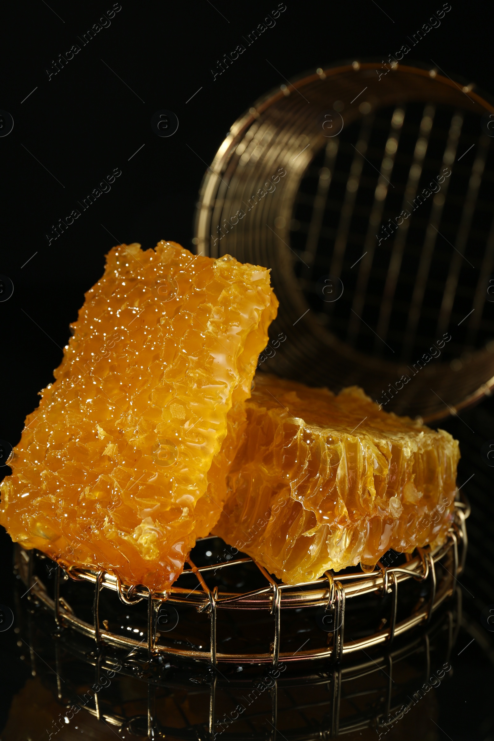 Photo of Natural honeycombs with tasty honey on black background