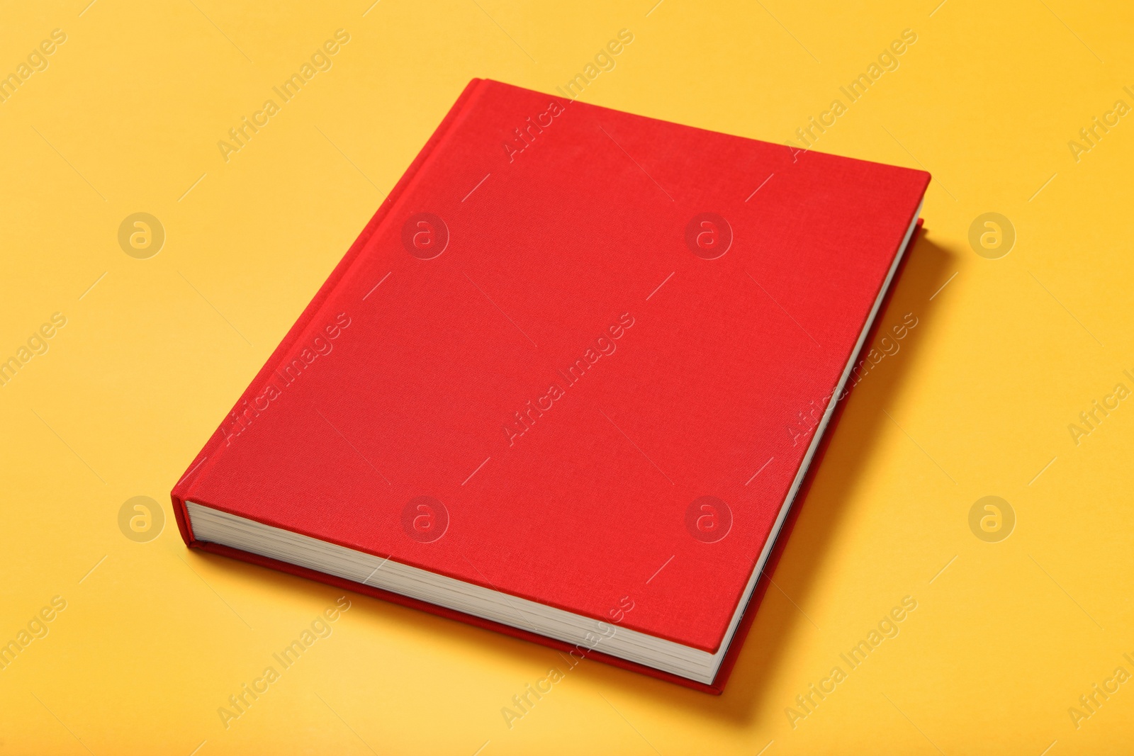 Photo of Book with red cover on yellow background