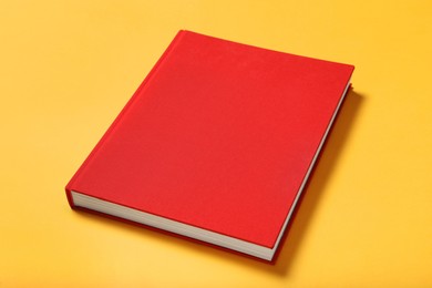 Photo of Book with red cover on yellow background