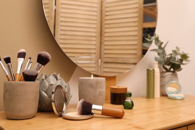 Wooden dressing table with round mirror and makeup products