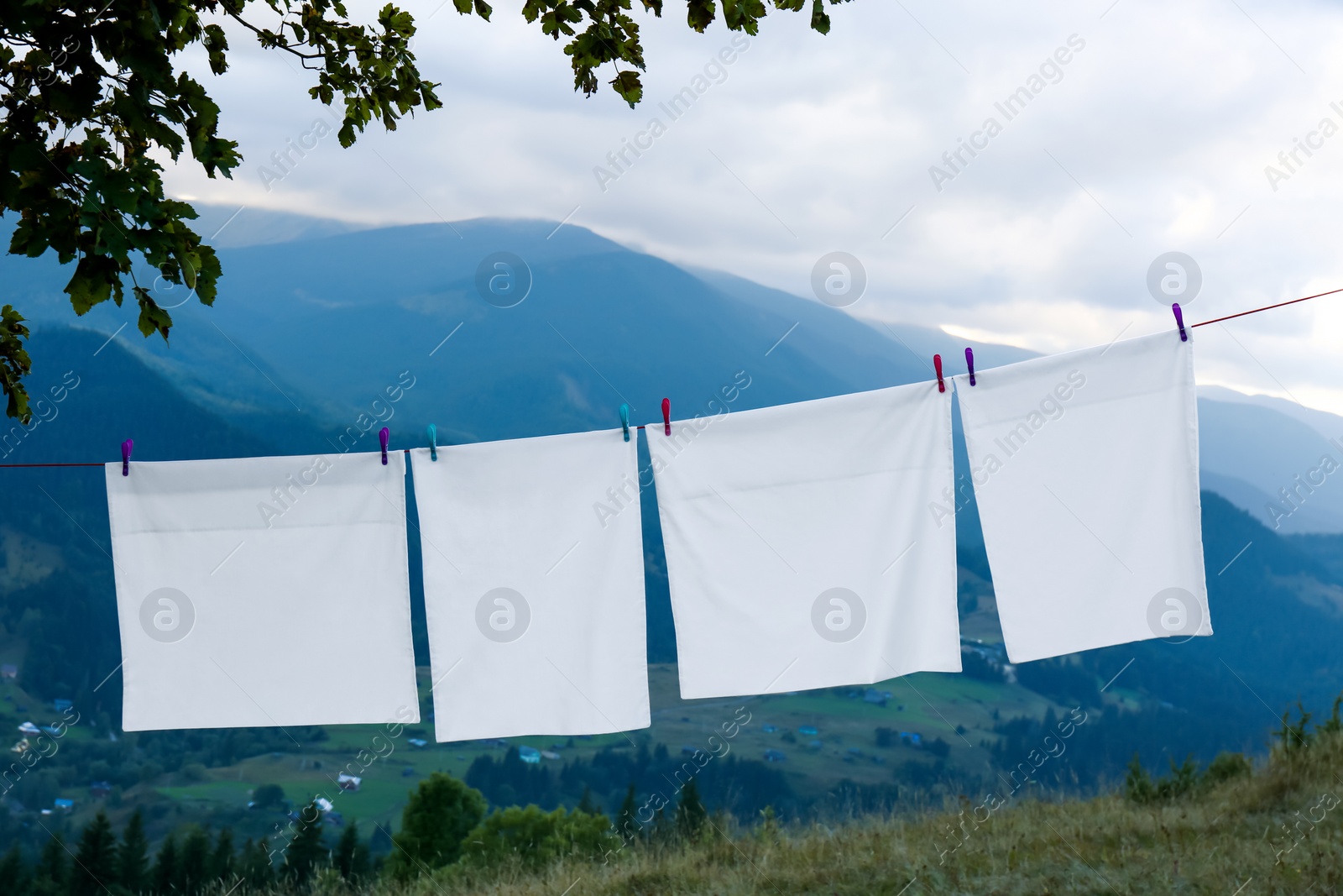 Photo of Bedclothes hanging on washing line in mountains